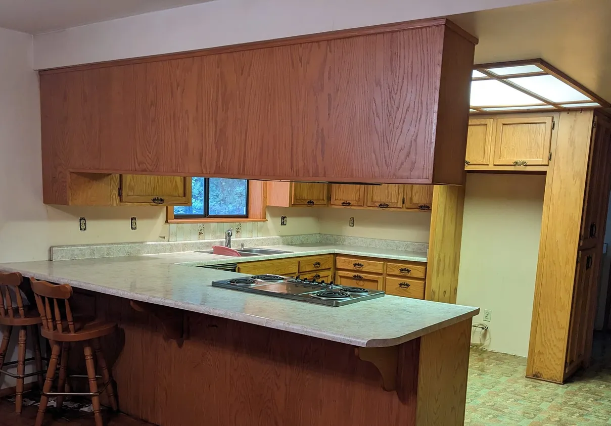 Residential kitchen with cleared counters and a wiped cooktop after a standard home cleaning.